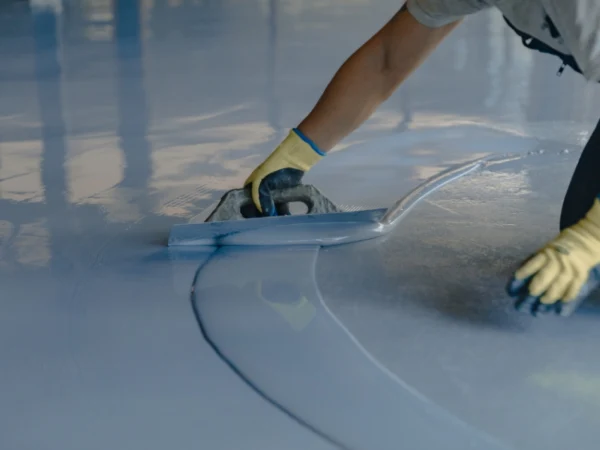 A worker from TJ Concrete Contractor team in San Antonio, TX completing an epoxy flooring project